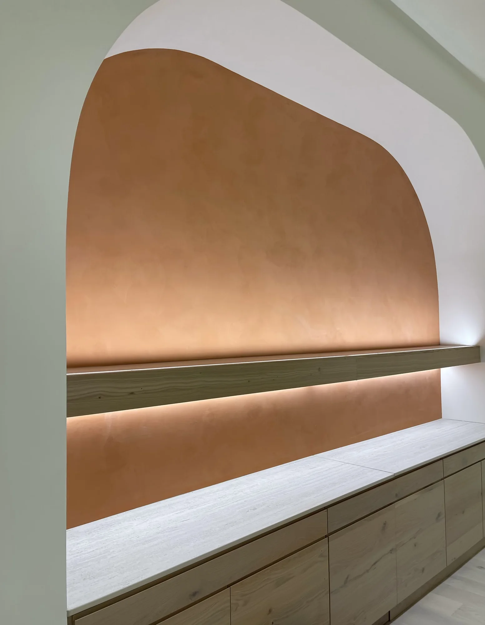 Warm bronze Marmorino arched niche with integrated lighting