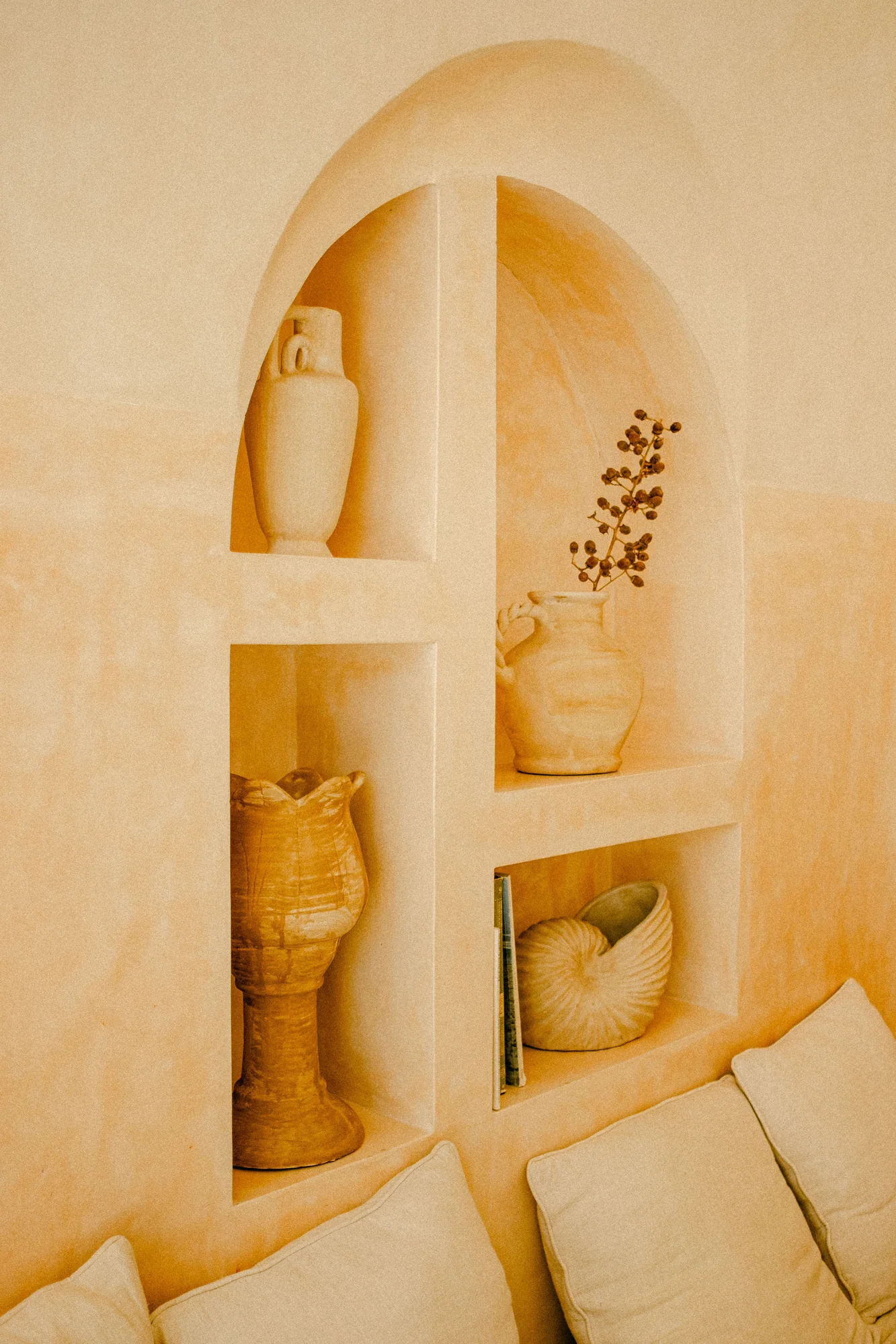 Warm ochre Tadelakt wall with sculpted display niches