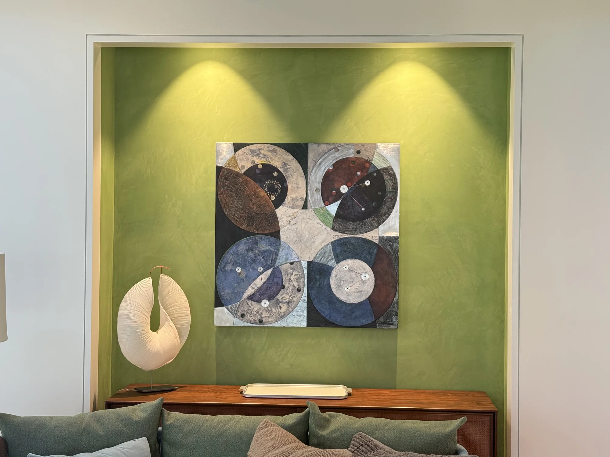 Sage green plaster feature wall with illuminated artwork
