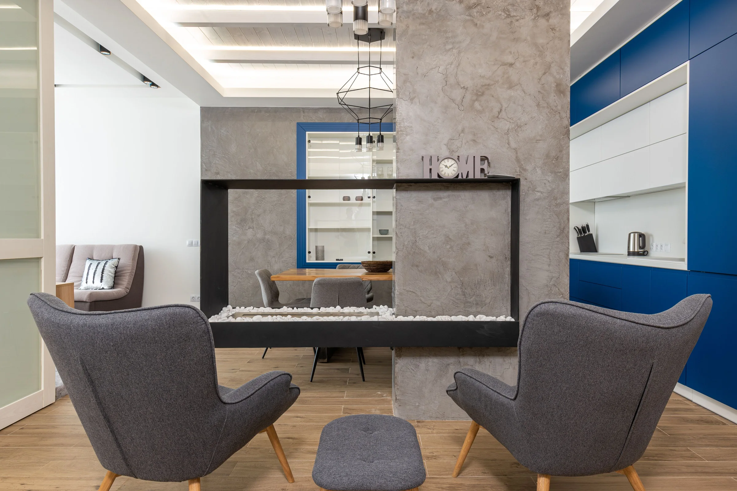 Grey mineral plaster surrounding a black fireplace
