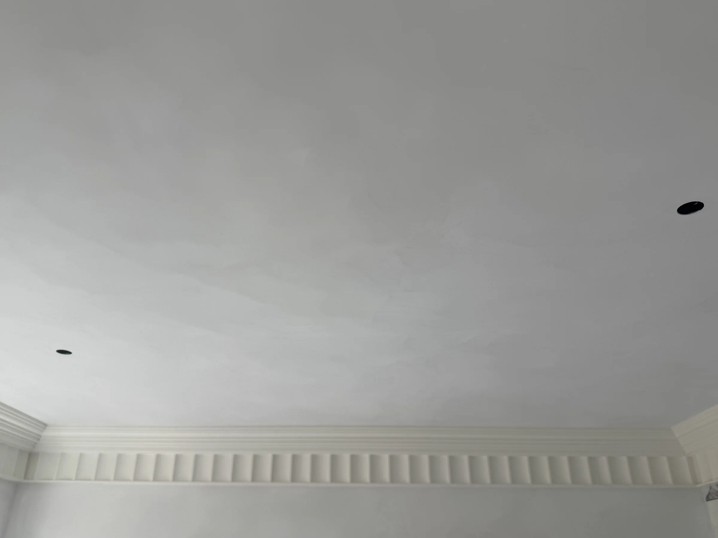 Subtle hand-applied movement across a pale ceiling